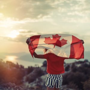 Jeune fille agitant fièrement un drapeau du Canada