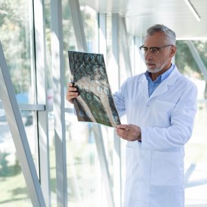 Médecin compétent portant une blouse de laboratoire tout en examinant les résultats d'un patient.