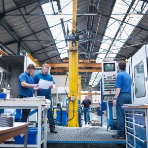 Groupe d'ingénieurs au poste de travail dans une usine d'ingénierie.